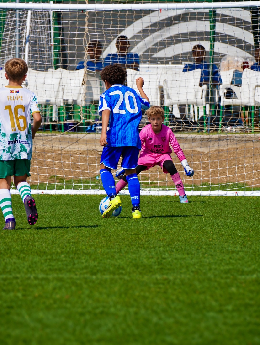 Goalkeeper in pink ready as an outfield player takes a penalty