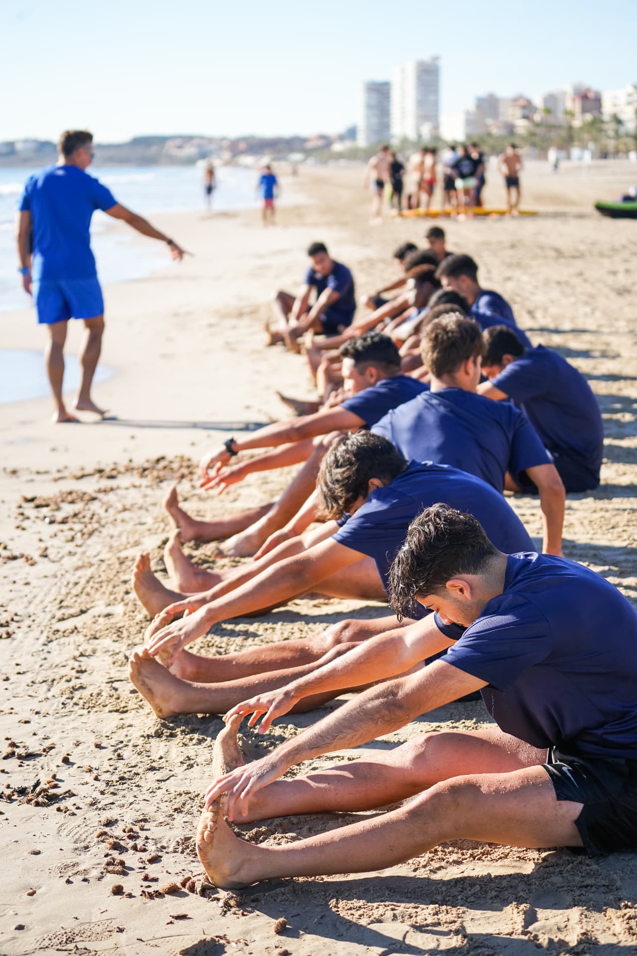 Team stretching on Playa de San Juan