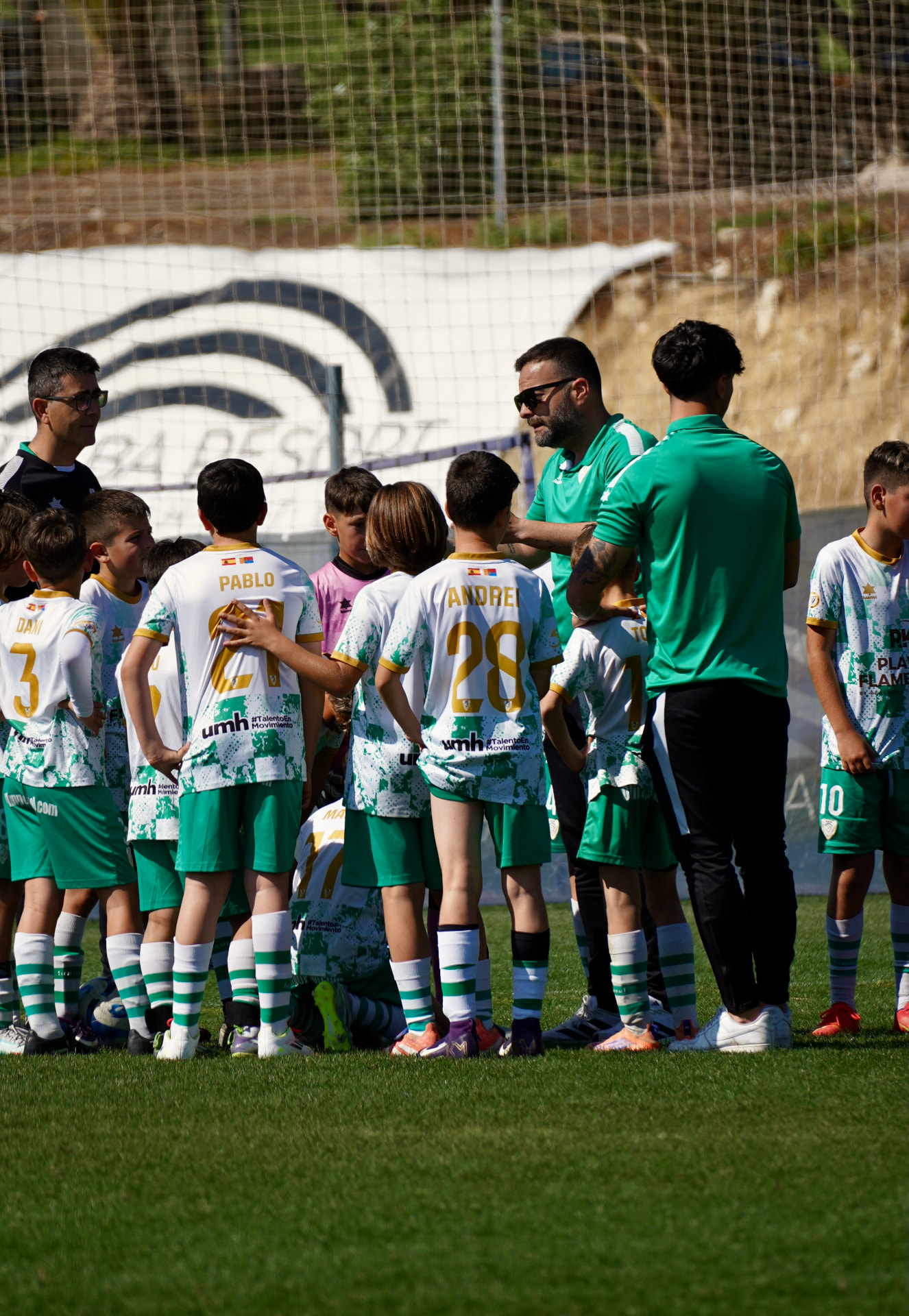 Junior team in a huddle listening to their coach before a fixture