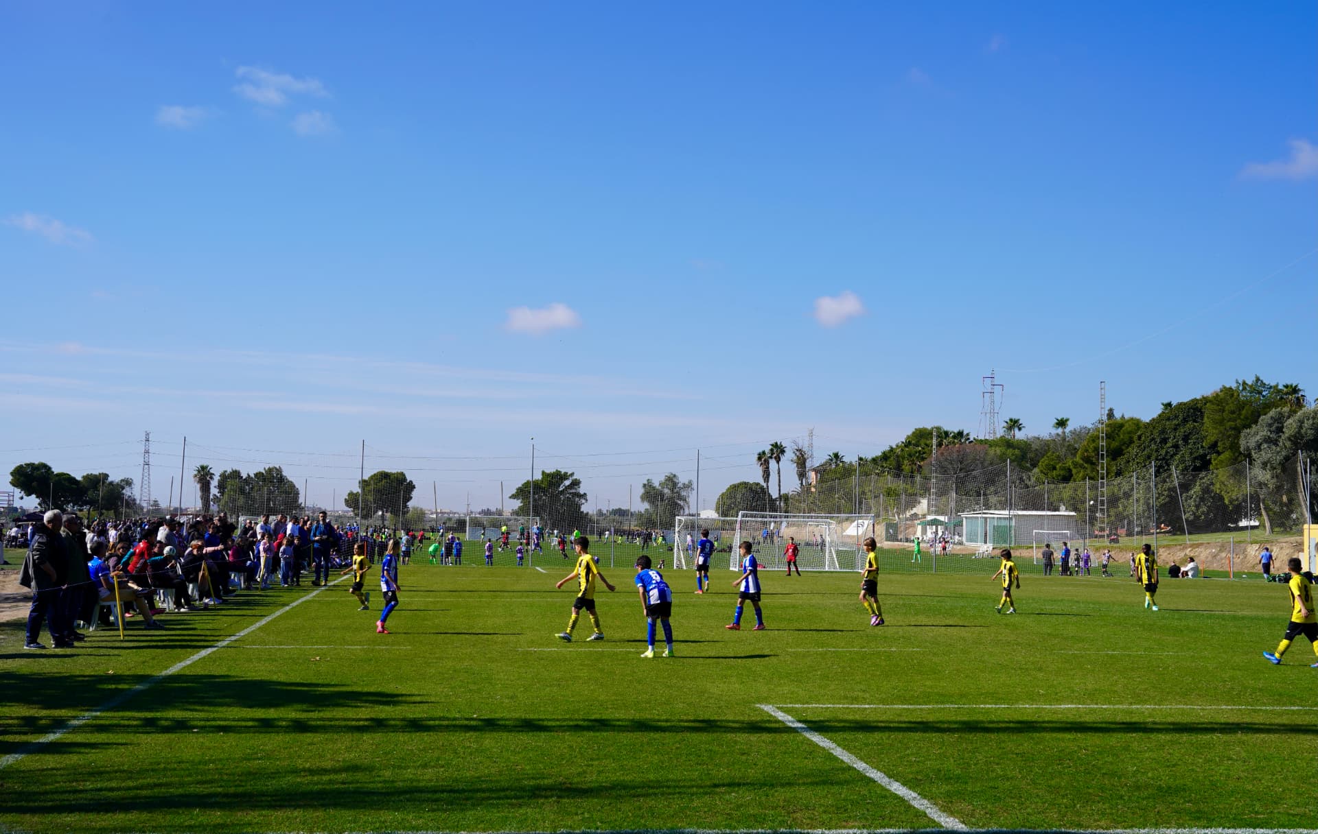 Junior teams playing a tournament match with spectators along the touchline