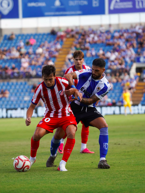 Match action in Alicante — player in blue and white stripes competing with an opponent in red and white