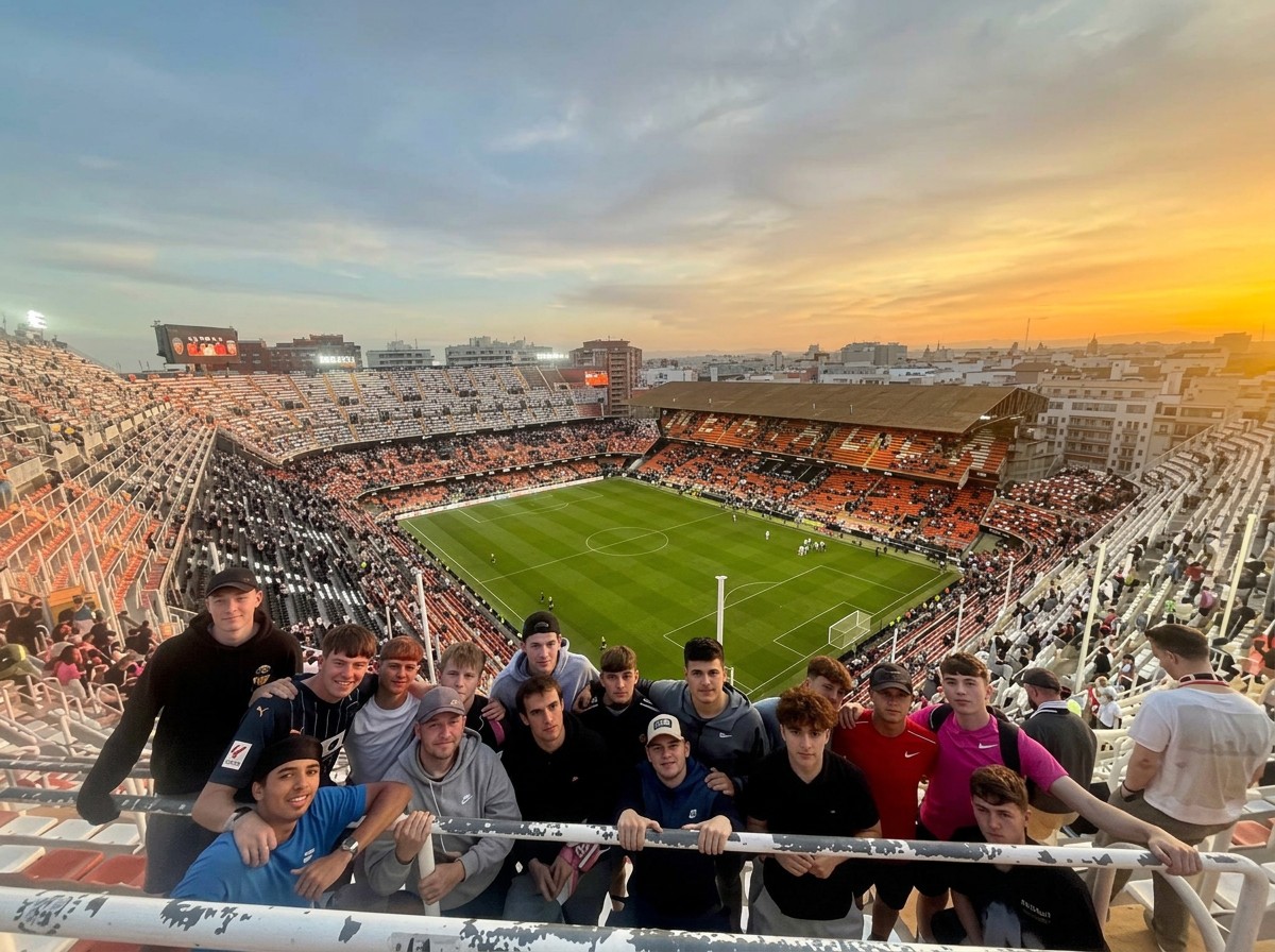 Students watching a live match from the stands of a packed Valencia stadium